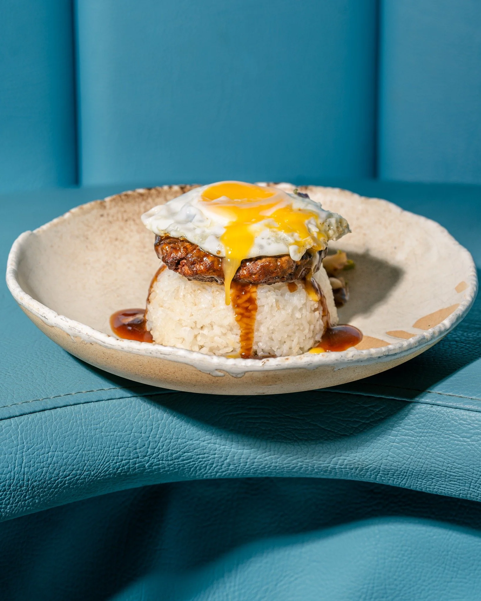 A Hawaiian classic, the Loco Moco. If you haven't tried one yet, add it to the list. 
Steak Burger Patty + Sticky Rice + Soy Gravy + Pineapple Salsa
+ Runny Fried Egg.
 If you are in the middle of a health kick, this is a high-protein dish that wil