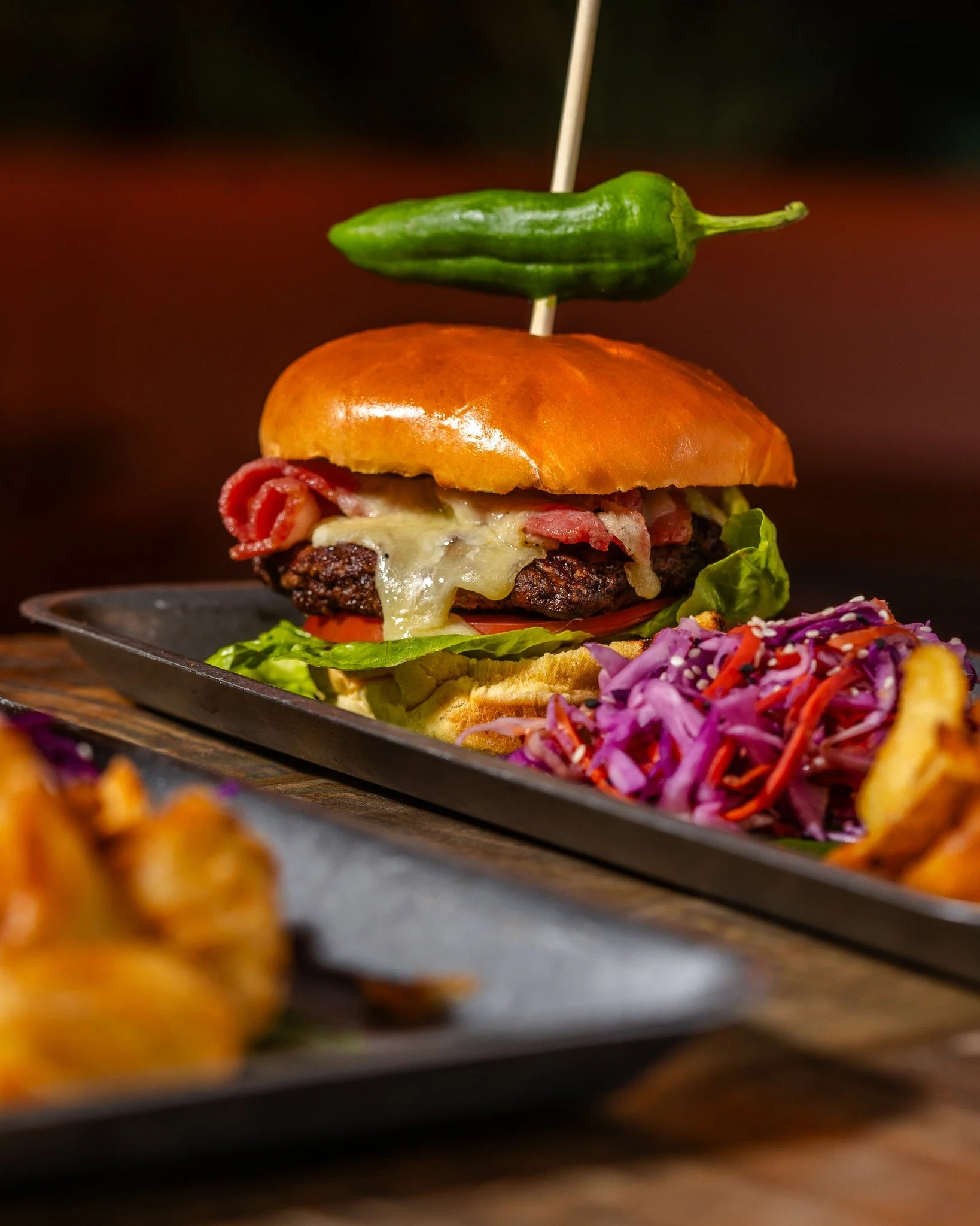 Big Burger, Big Bite. Next time you're in get stuck into our Beach Burger! 
 
Two Homemade Signature Beef Burgers + Bacon + Cheese + Padron Pepper + Dressed Rocket + Tomato + Pickled Slaw + Brioche Bun + Wela Spiced Mayo + Chips

Add Sticky Char Siu 