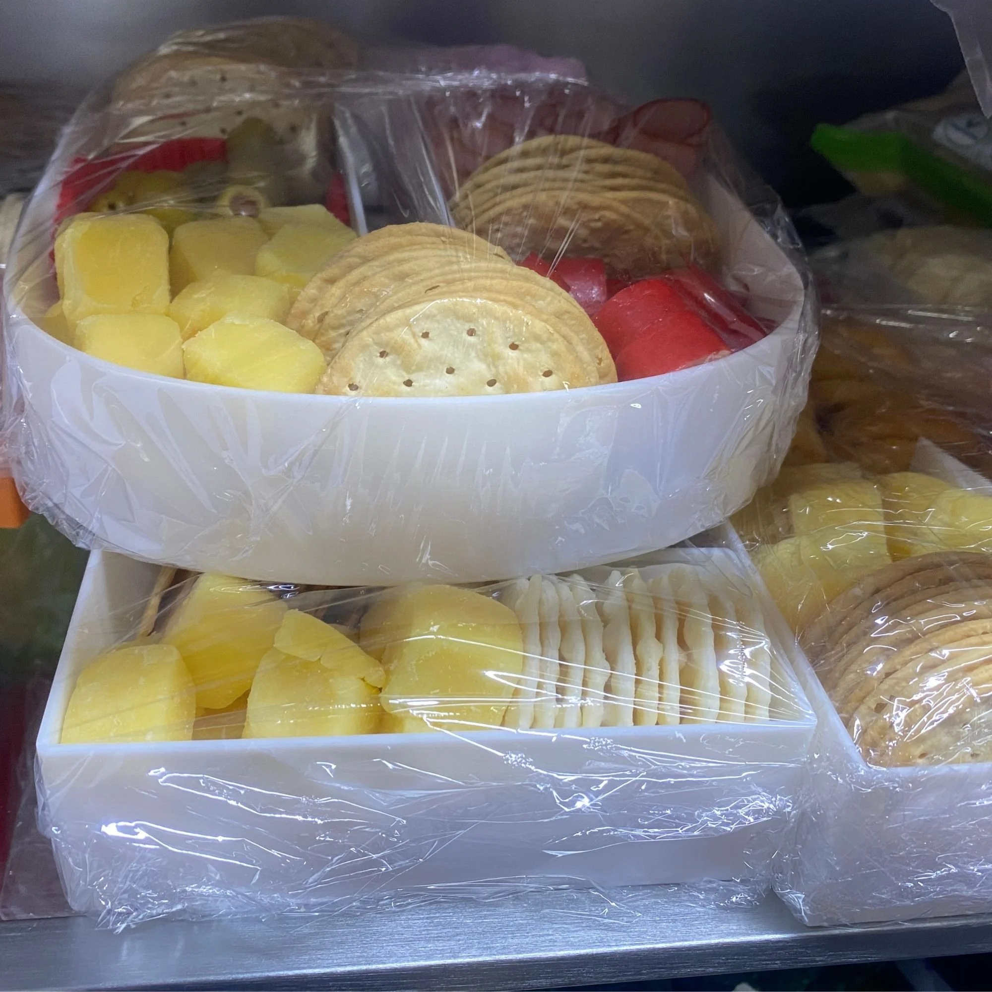 Charcuterie letters in fridge full of cheese, salami and ham