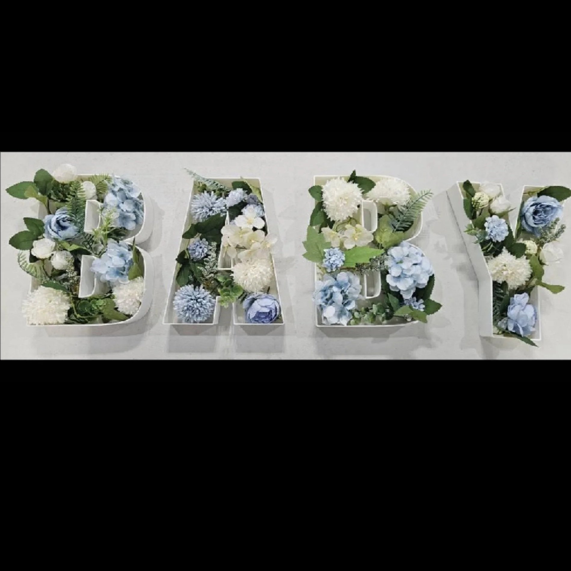 display of letters b a b y while decorated in blue and white flower display