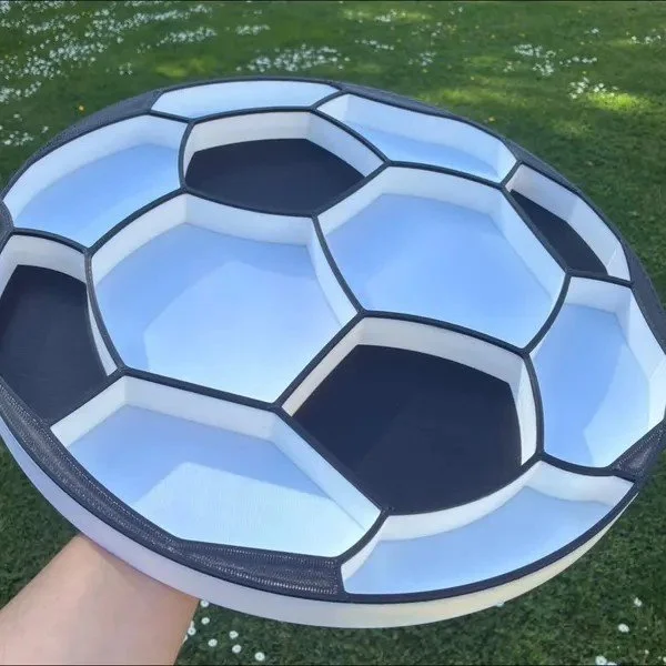 3d printed black and white soccer ball shaped food tray outside in the garden