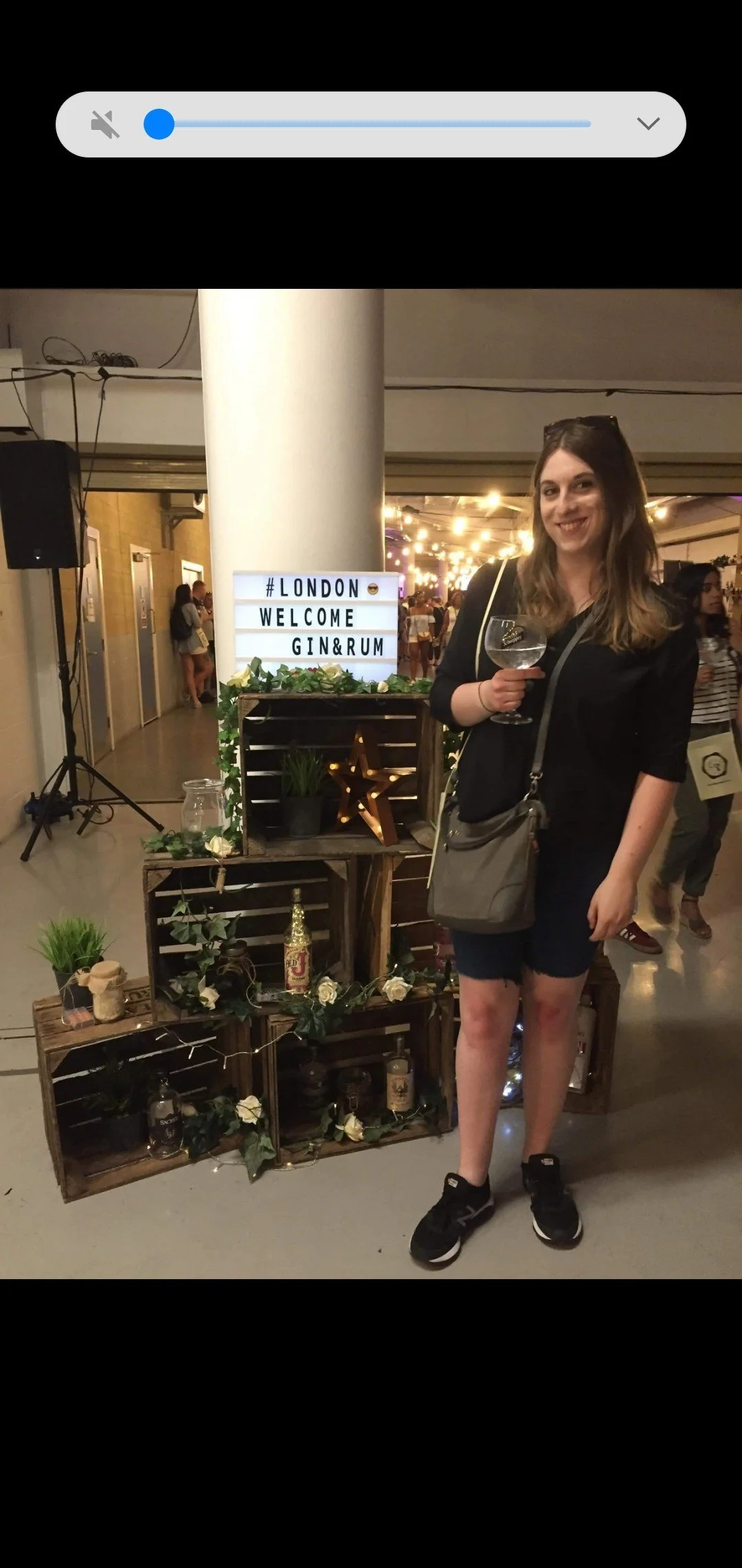 Georgia with a glass in her hand in a bar.