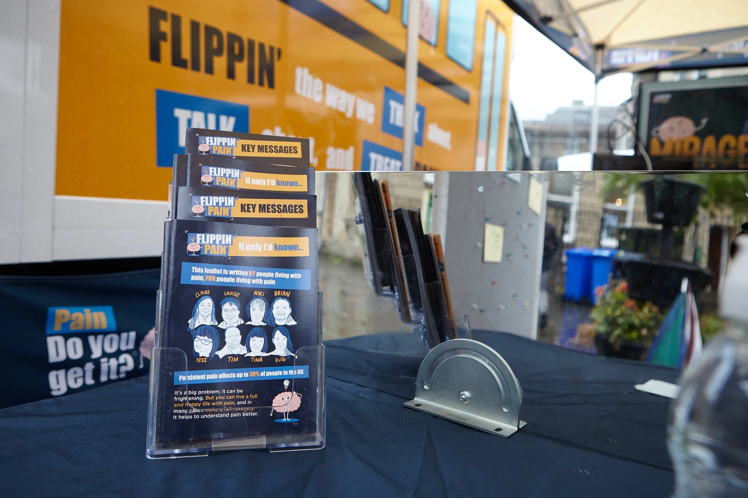 A leaflet stand with Flippin' Pain leaflets displayed.