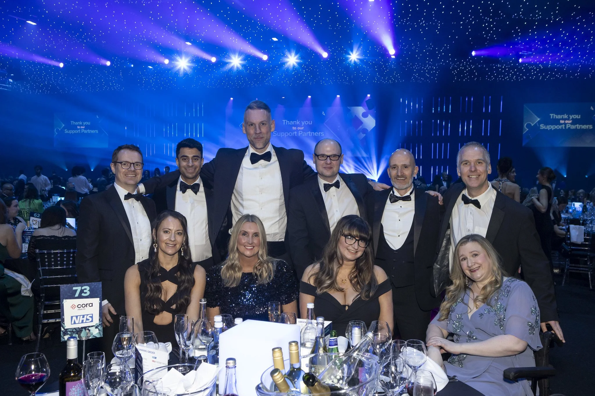 Members of the Flippin' Pain and Cora Health teams sat around a table at an awards event.