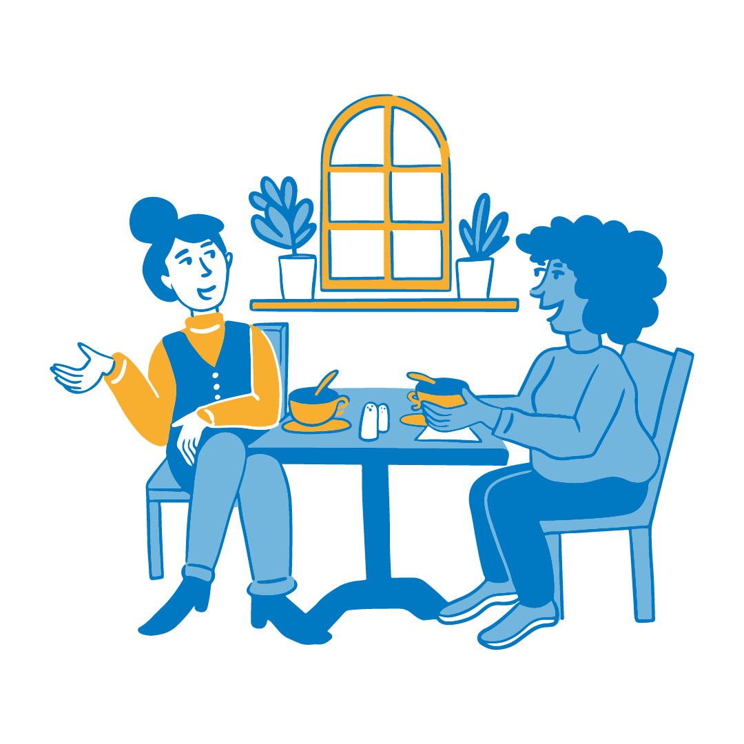 Two women chatting at a table over coffees.