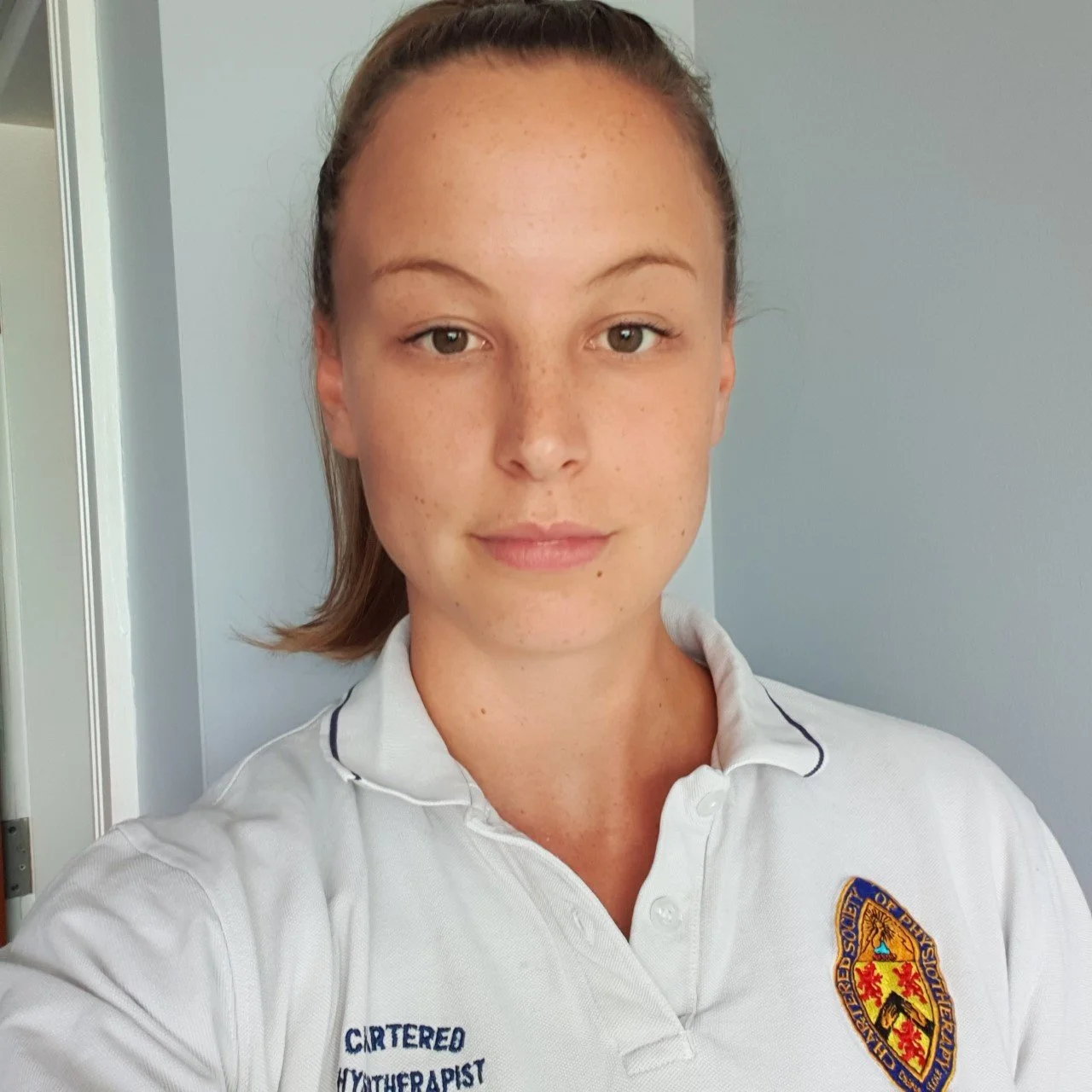 Becky in her physiotherapist uniform, smiling at the camera.