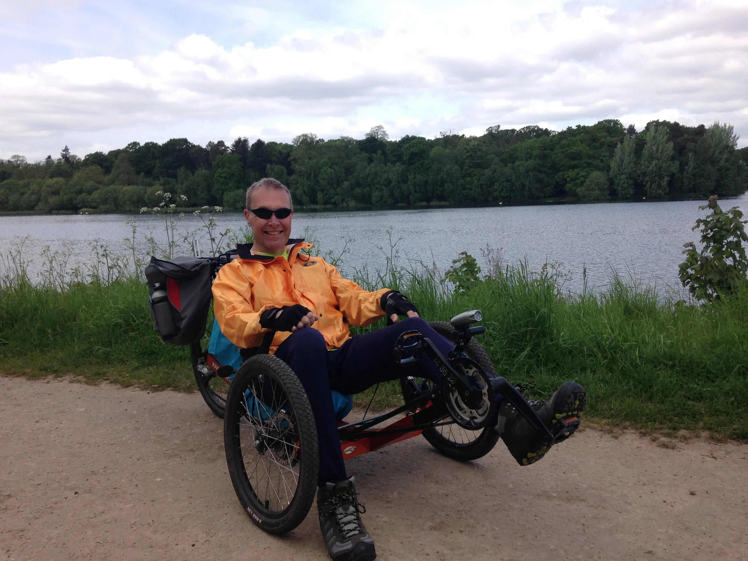 Ivor sitting in a recumbent trike in the countryside.