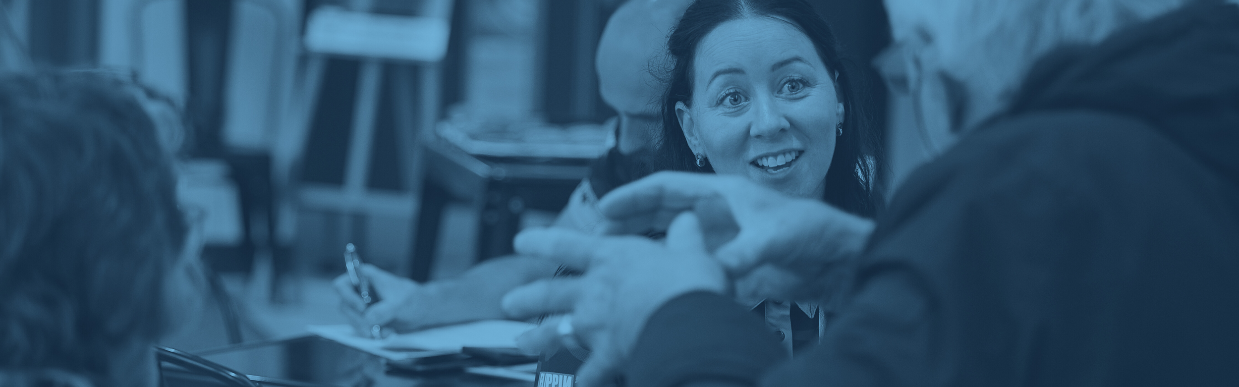 A woman listening and smiling to a man explaining.