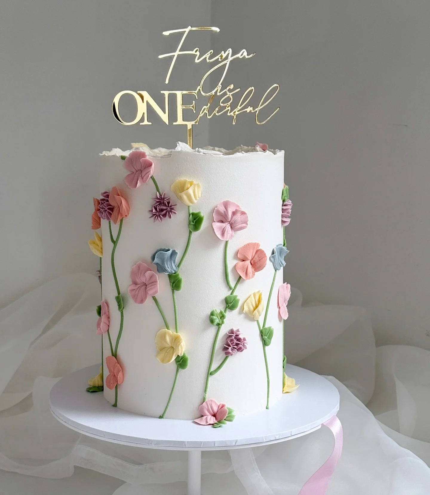 A colourful piped flower meadow for Freya&rsquo;s first birthday.

Acrylic gold topper by the fabulous @burntisland_occasions 

I am so behind on posting and I have so many images and videos to show you, I promise I will work my way through them all 