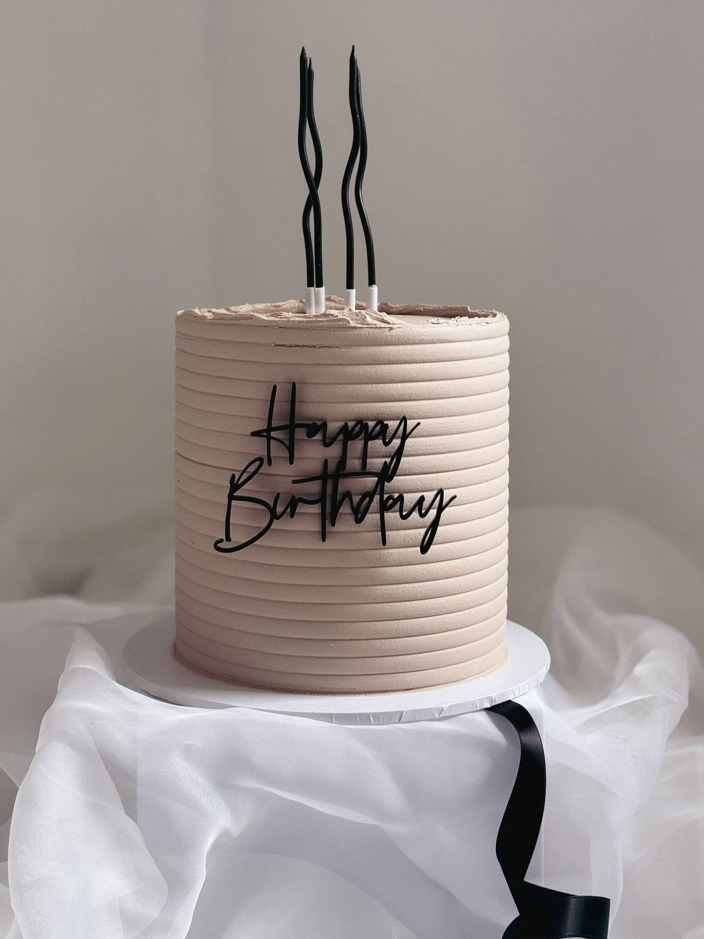 Happy Birthday 🖤

Latte and black with my new favourite accessory&hellip;wiggly candles! 

Ribbed textured buttercream with acrylic charm, simple, modern &amp; stylish. 

#birthday #birthdaycake #latte #black #happybirthday #candles #texturedcake #m