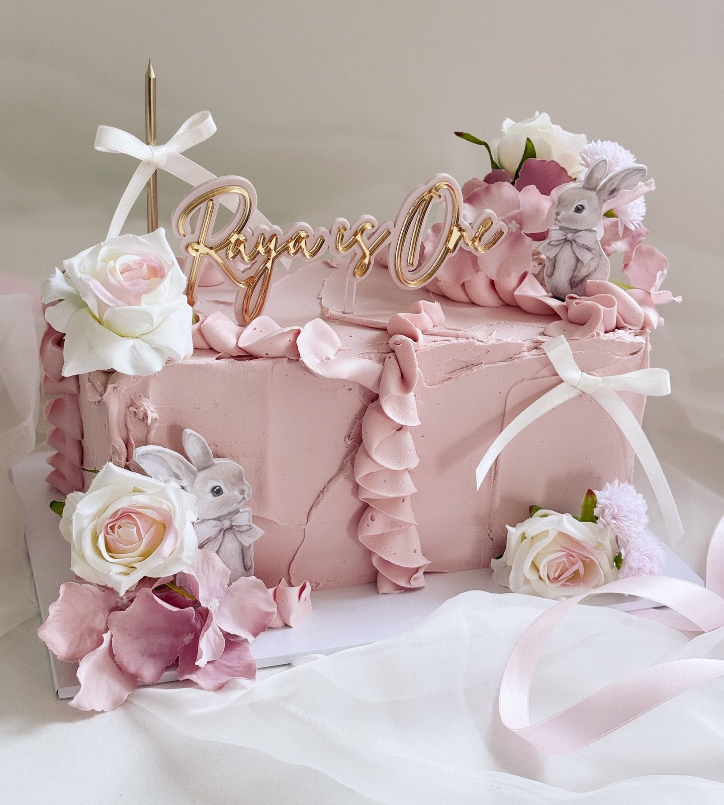 O N E 🐰

For me the rectangle is definitely the new round this year. A super cute floral, bunny themed cake for little Raya&rsquo;s first birthday. 

Acrylic wording &amp; printed charms @burntisland_occasions 

#firstbirthdaycake #bunnycake #rectan