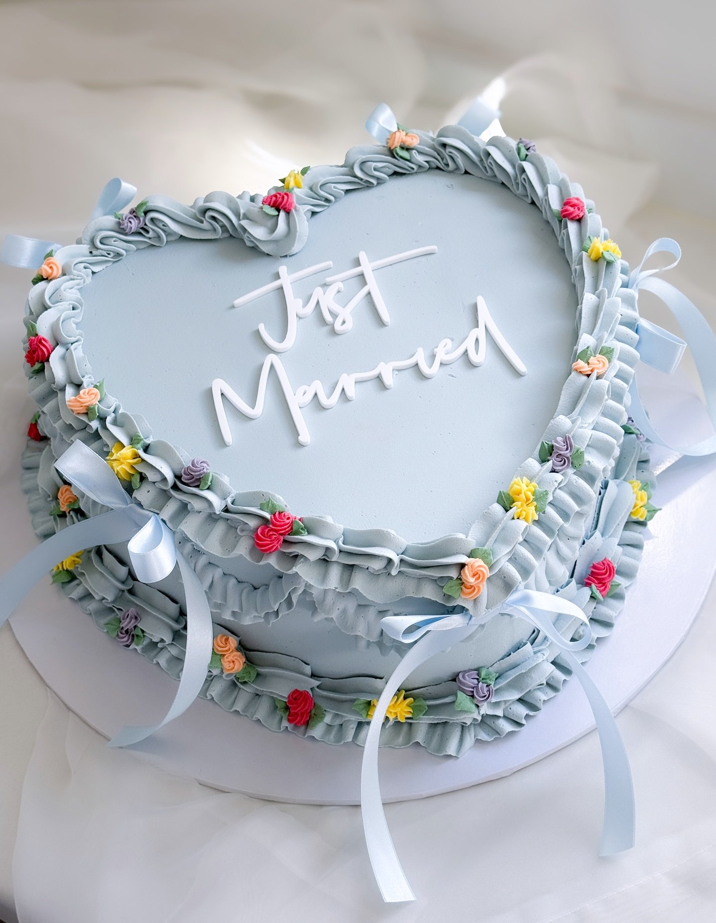 Something blue for Leah &amp; David. A beautiful wedding full of colour! 

An extra large white chocolate &amp; raspberry heart cake with bright piped roses &amp; bows.

Acrylic wording @burntisland_occasions 

#weddingcake #heartcake #somethingblue 