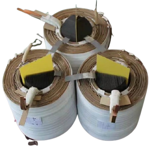 Three large rolls of adhesive tape standing upright with various tools attached to their tops, viewed from above.