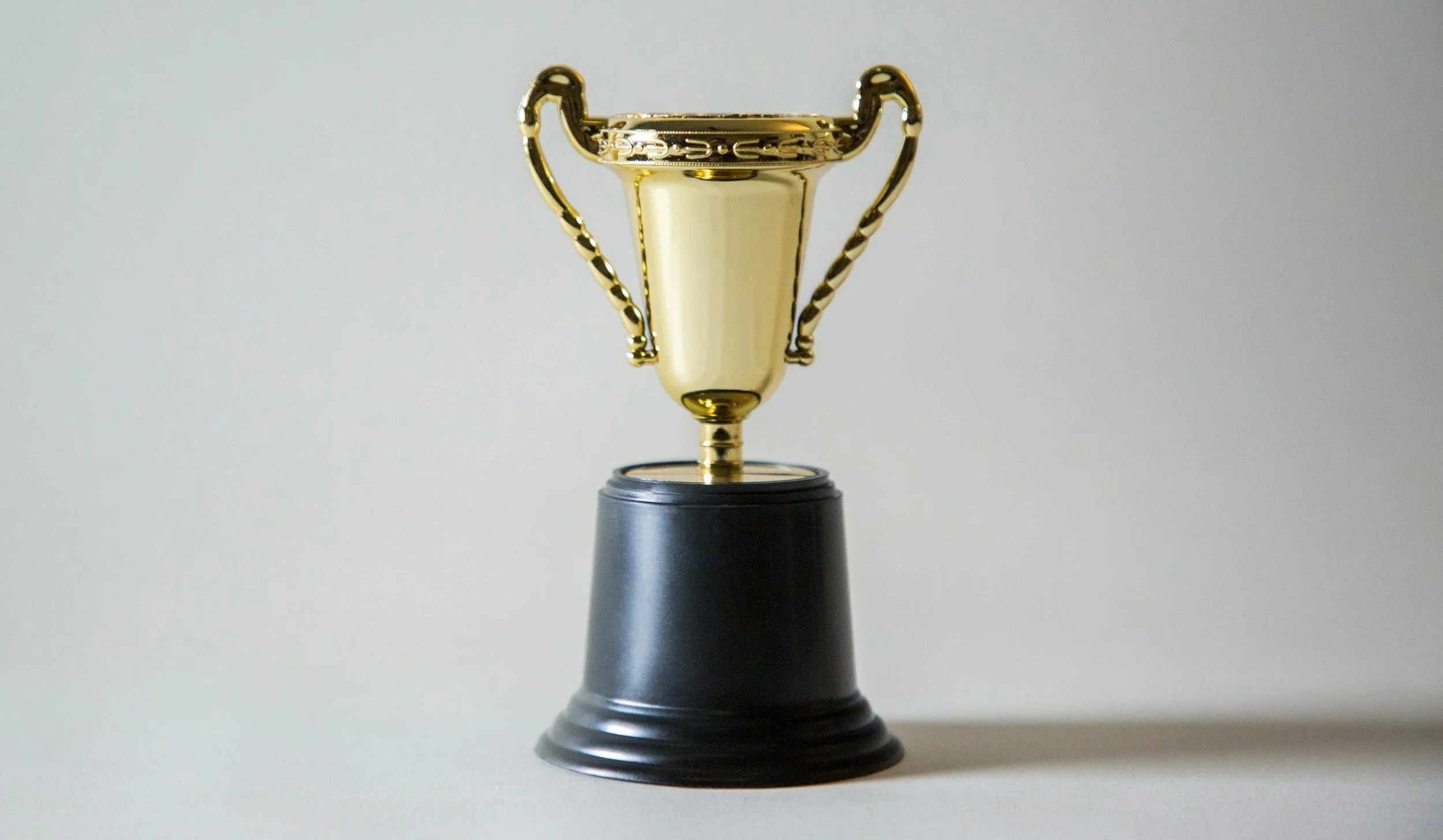trophy with a shadow sat on a pure grey background