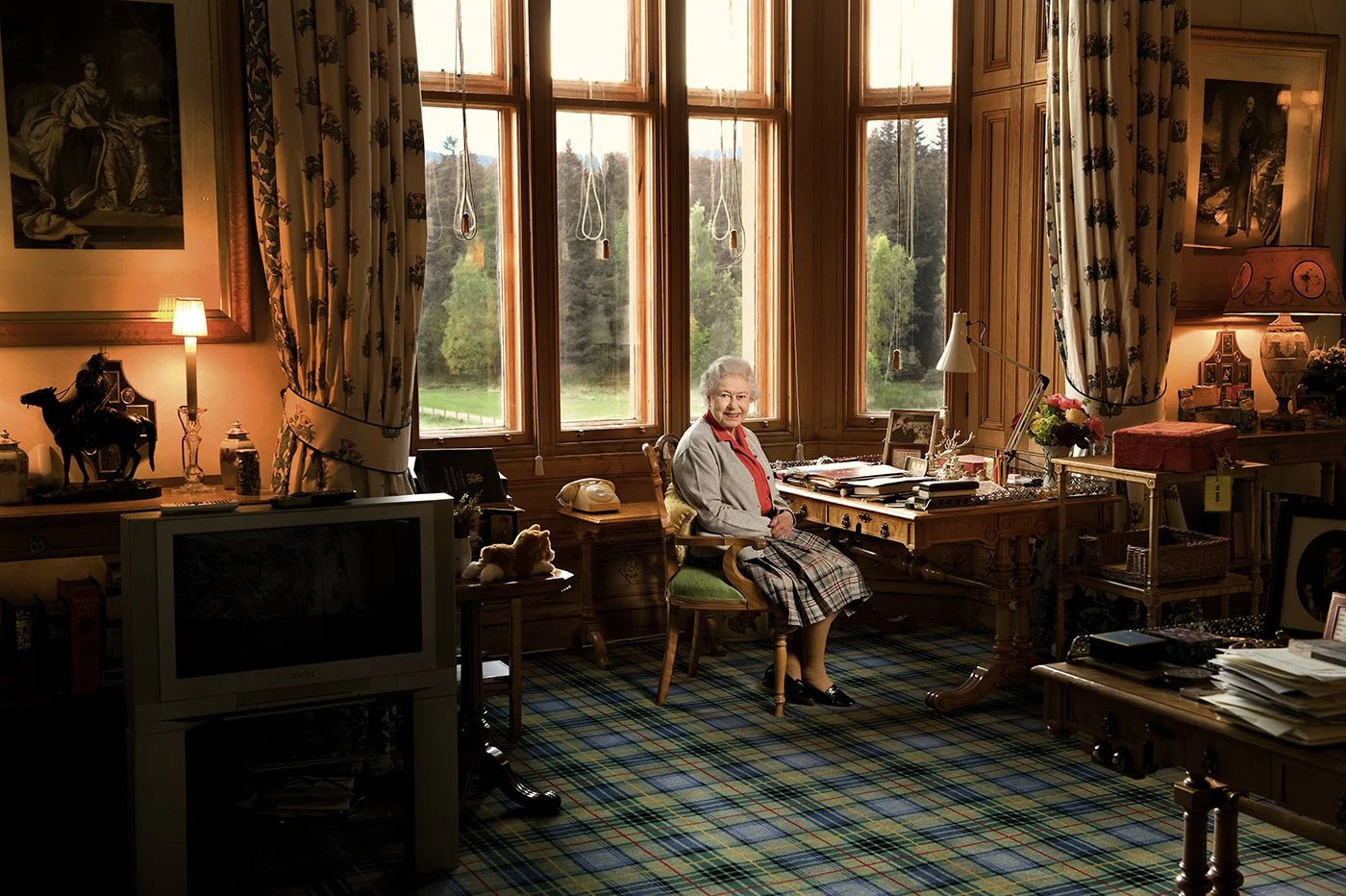 Queen Elizabeth II at work at her desk in Balmoral. I asked her if I could take this portrait to show that even though she is on holiday she attends to the red boxes each morning.
