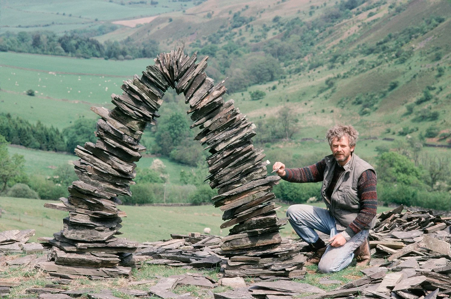 Andy Goldsworthy with a stone arch work near his home in Penpoint, Scotland