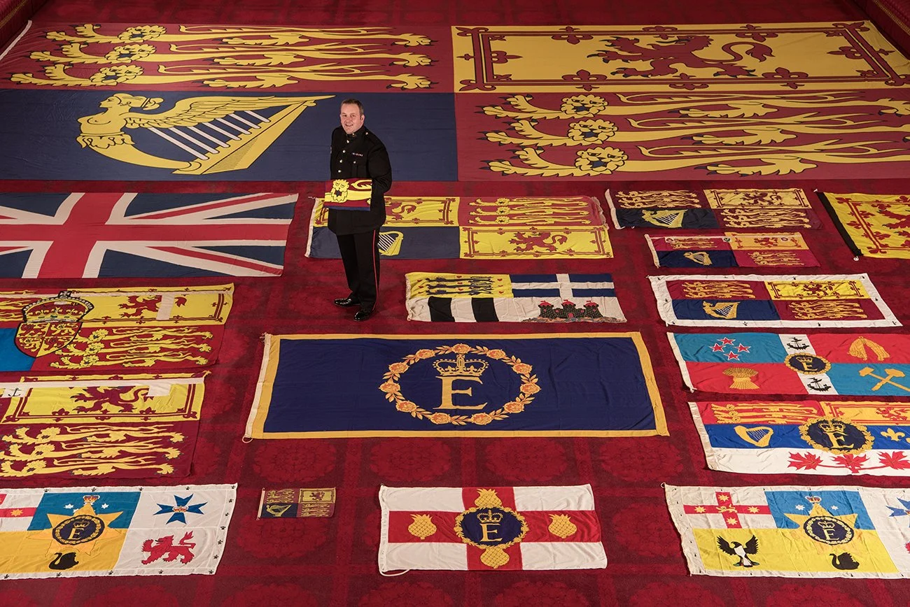 The Queen's Flag Sergeant. Every year all the flags are laid out on the ballroom floor in Buckingham Palace to check they are in perfect condition