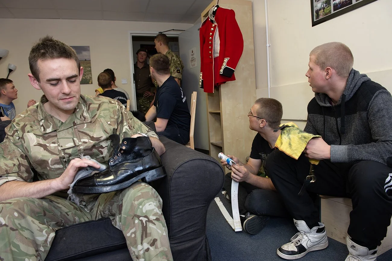 Shining boots, cleaning and pressing kit prior to going on parade
