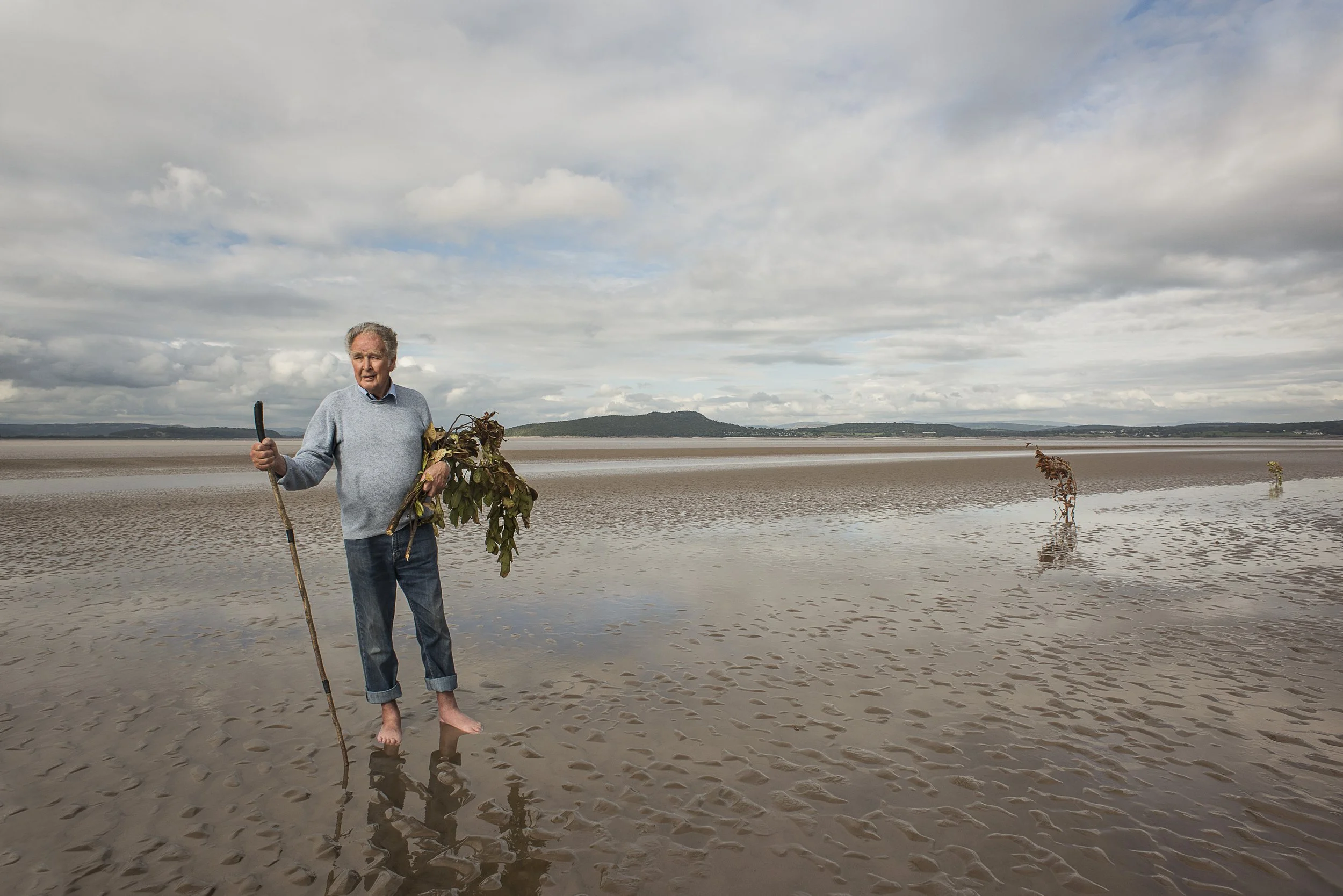 The Queen's Guide over Kent Sands, Cedric Robinson, holds 'brobs' of laurel that mark the safe path across the bay  