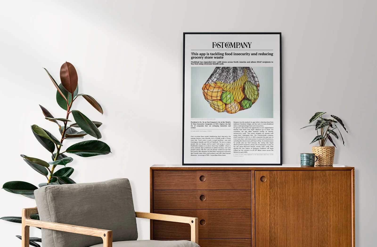 A Fast Company article in a black frame, hanging above a wooden sideboard