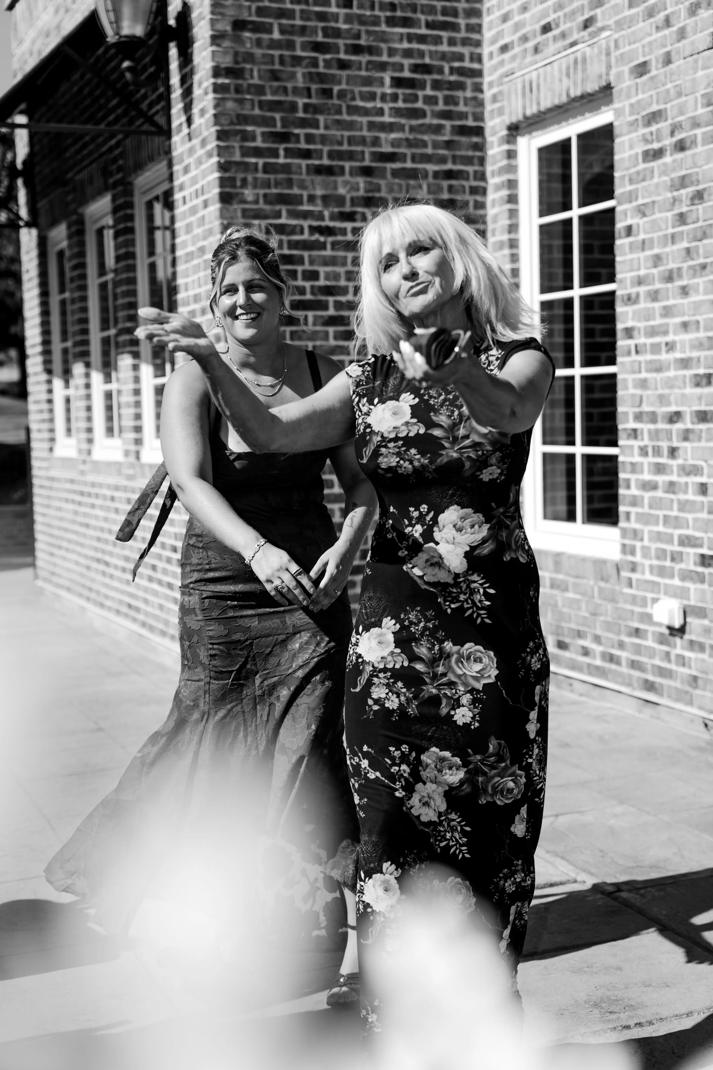 Two women smiling during a wedding celebration outside a historic venue. Documentary wedding videography focused on real interactions, natural emotions, and inclusive love stories throughout New Jersey, New York, and destination weddings.