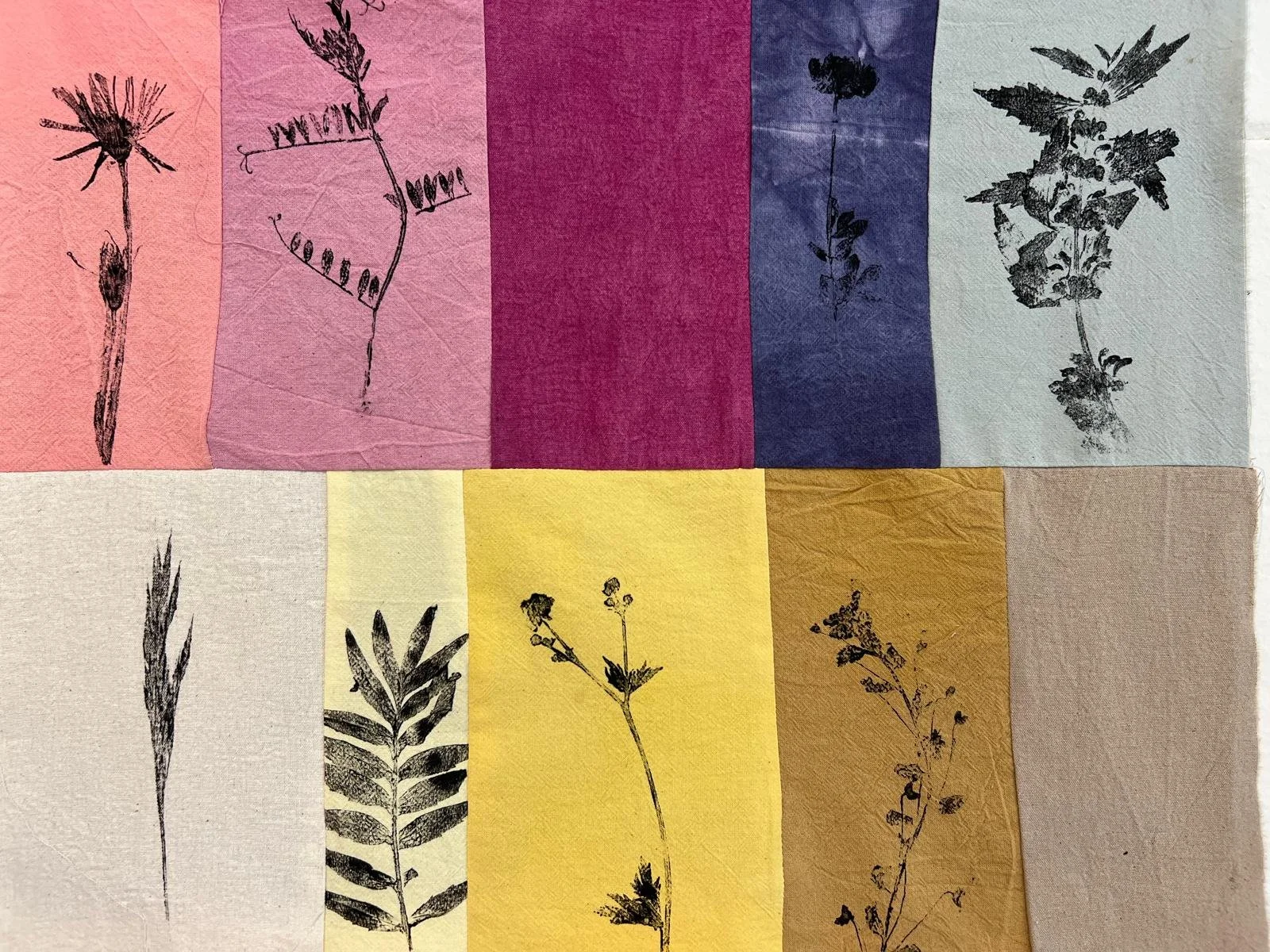 Bunte Stoffstreifen in Rosa, Gelb, Blau und Violett mit gedruckten Blüten und Gräsern