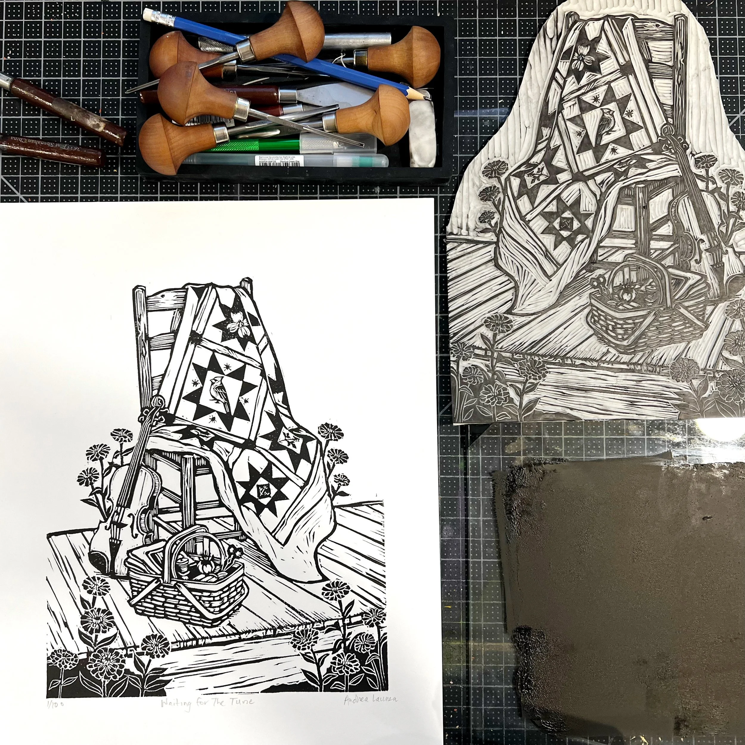 Original linocut printing block displayed beside the completed hand-pulled print.