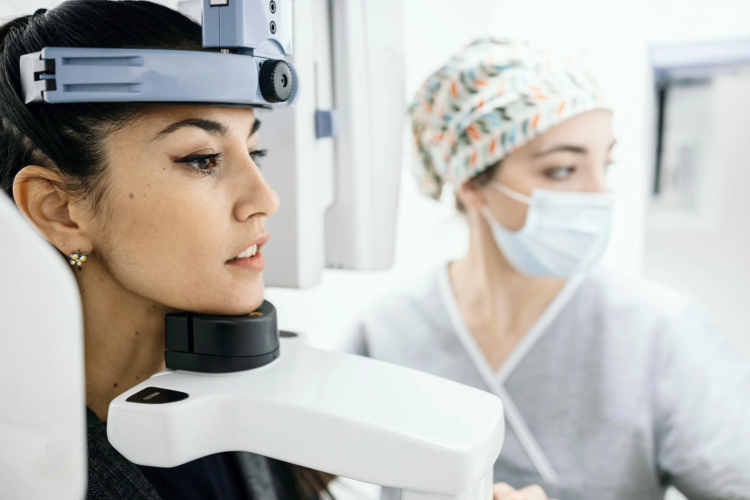 An imaging technician performs a CBCT scan on a patient.