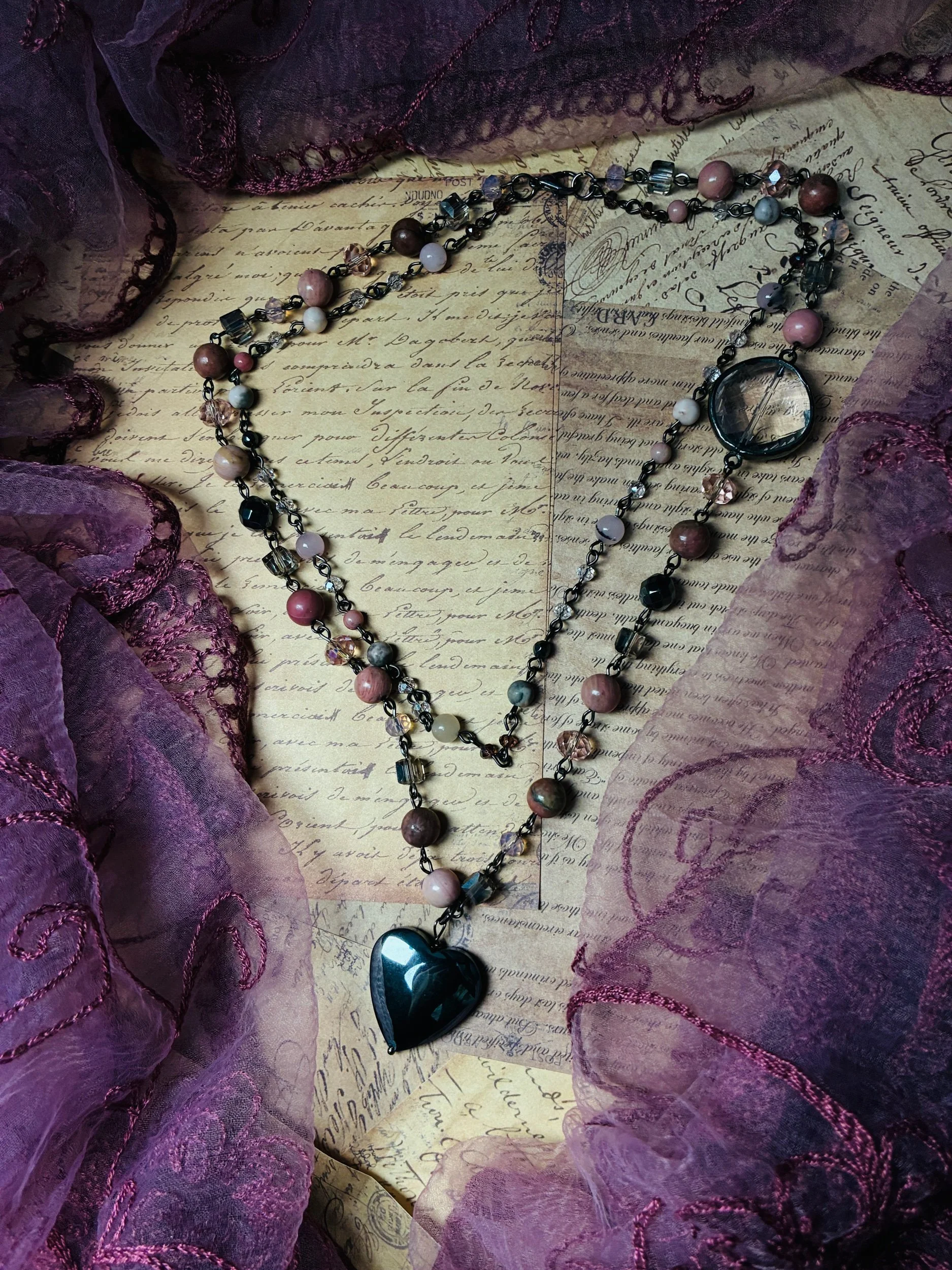 Close-up of the heart pendant and romantic pink and smoky-gray beadwork on the Rosewater necklace.