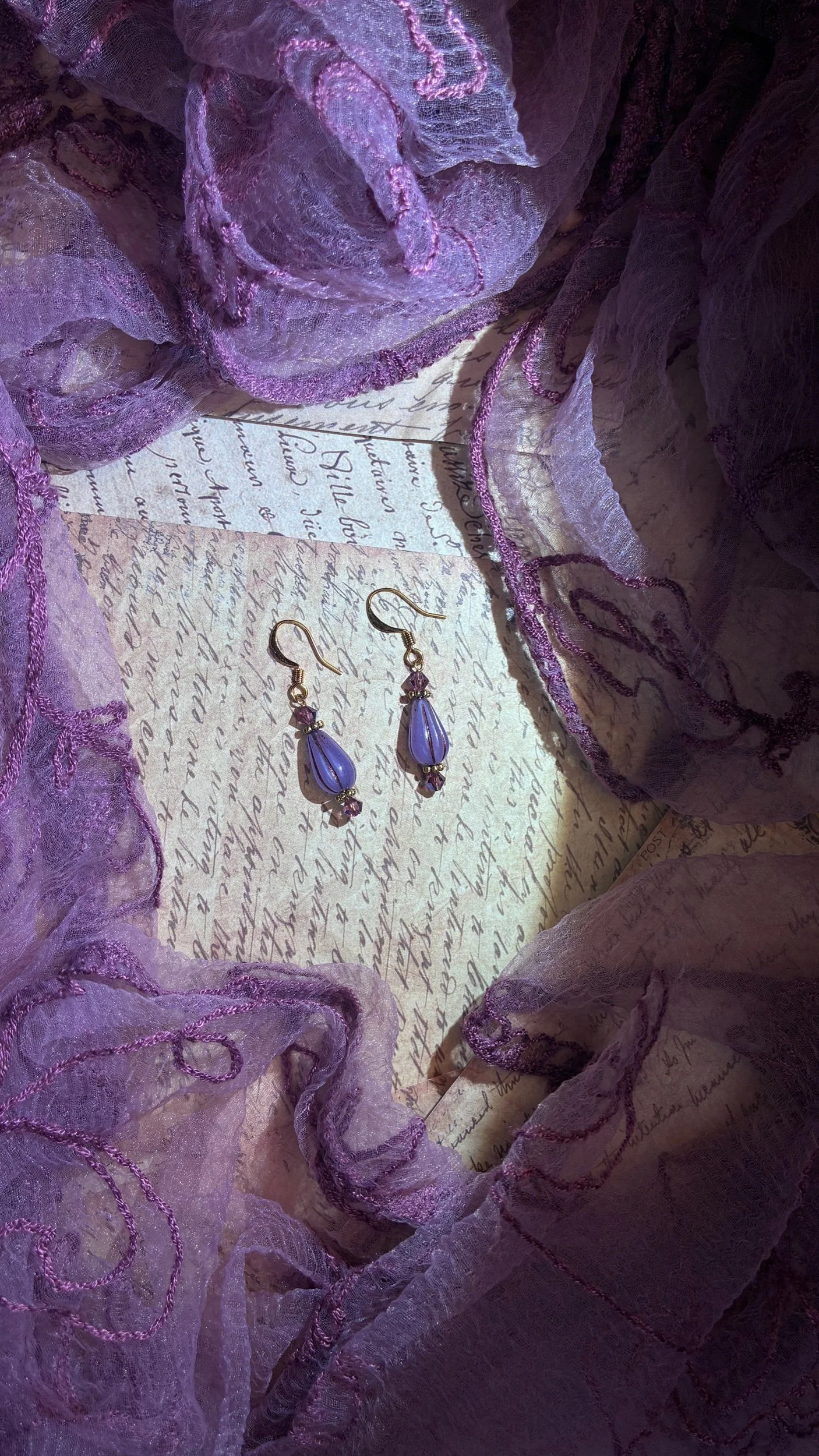 Close-up of the translucent blue glass and iridescent beadwork on the Elixir earrings.