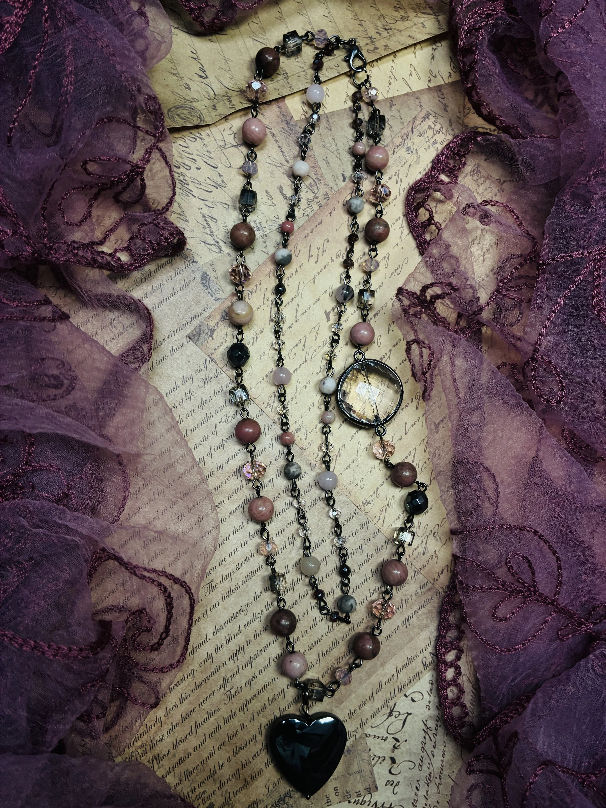 Rosewater layered pink and gray beaded necklace with a dark heart-shaped pendant.