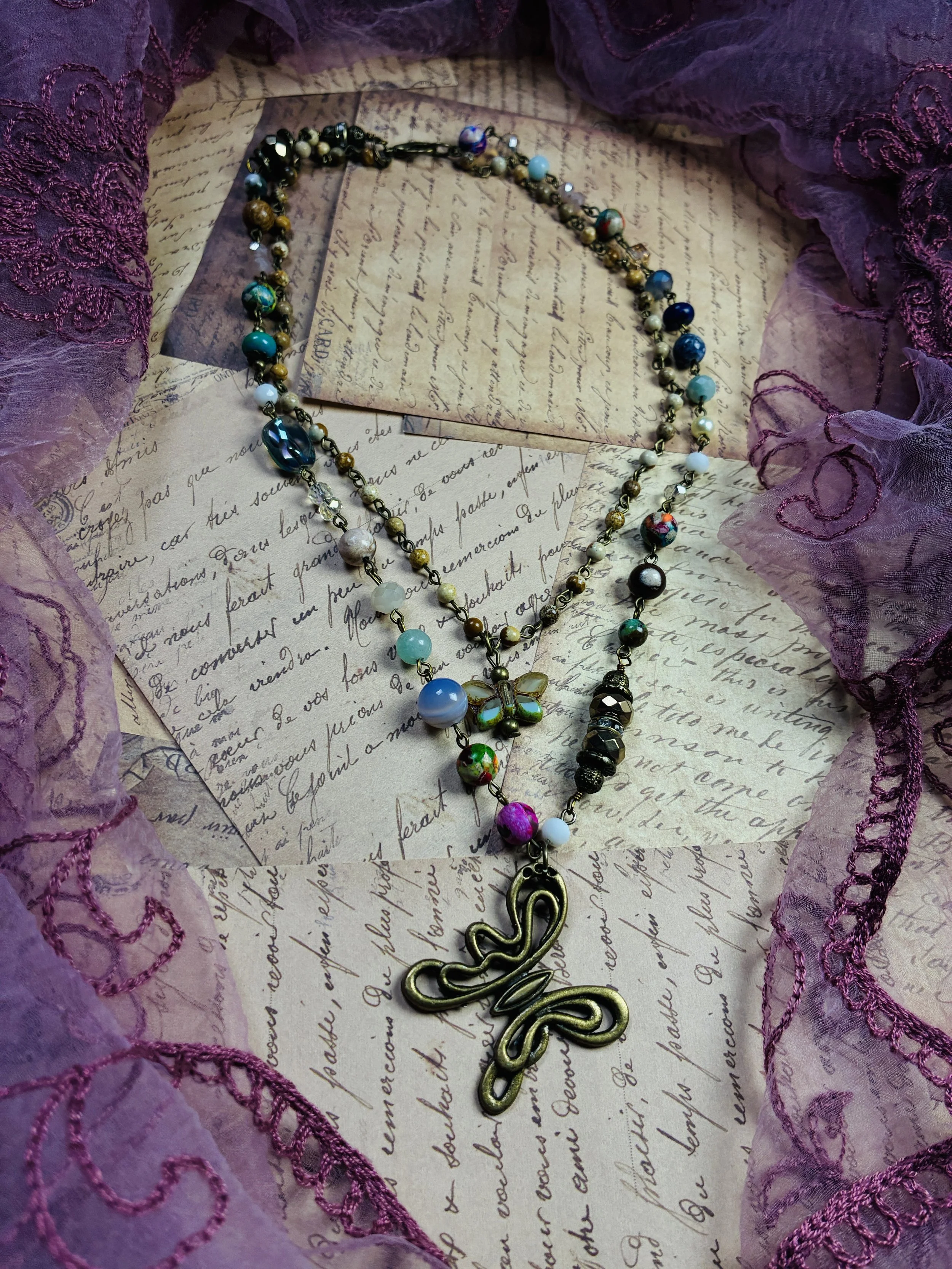 Mariposa layered beaded necklace with butterfly accents and an antique-style butterfly pendant.