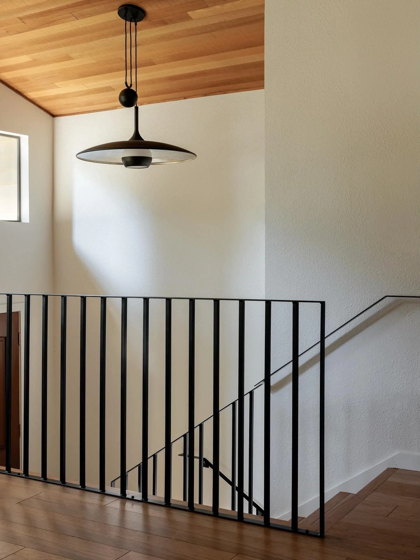 New flooring and a new iron railing did wonders for this entry but the real cherry on top is the pendant - one of my favorite light fixtures in this whole project 🖤 swipe for the before. 
.
First photo by @alessandrabrescia.ab 
.
.
.
#homeware
#home