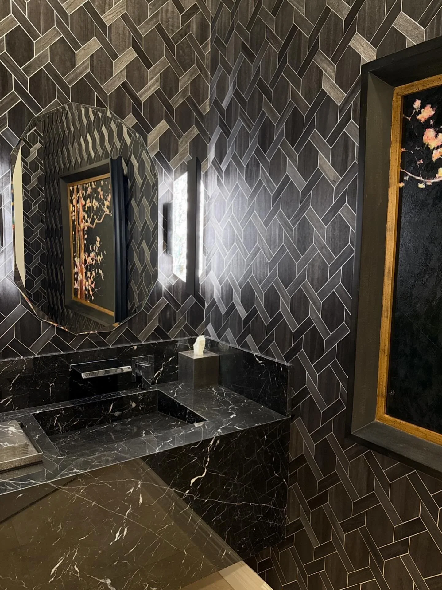 ✨ Bold. Geometric. Sophisticated. ✨ Our clients sophisticated powder room. 
This powder bath proves that small spaces can make the biggest statements. Layered black marble, moody lighting, and graphic walls create a dramatic retreat that feels both l