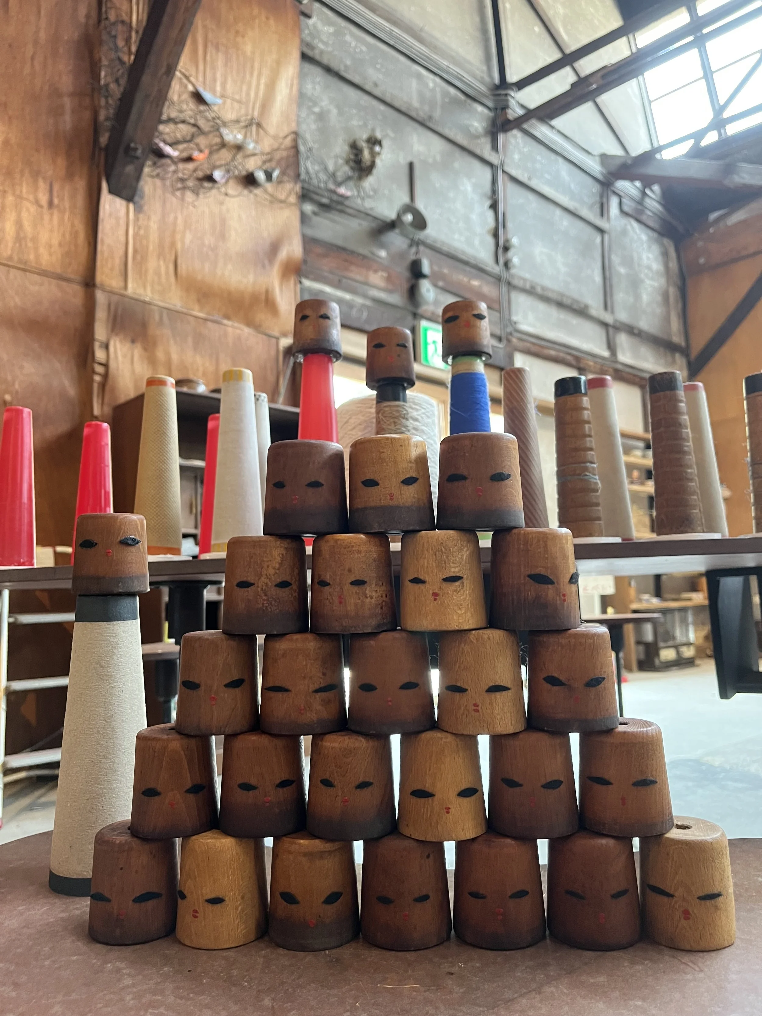 Detail of some painted faces of 31 "the Kokeshi Dolls* of  Factory Girls”* 