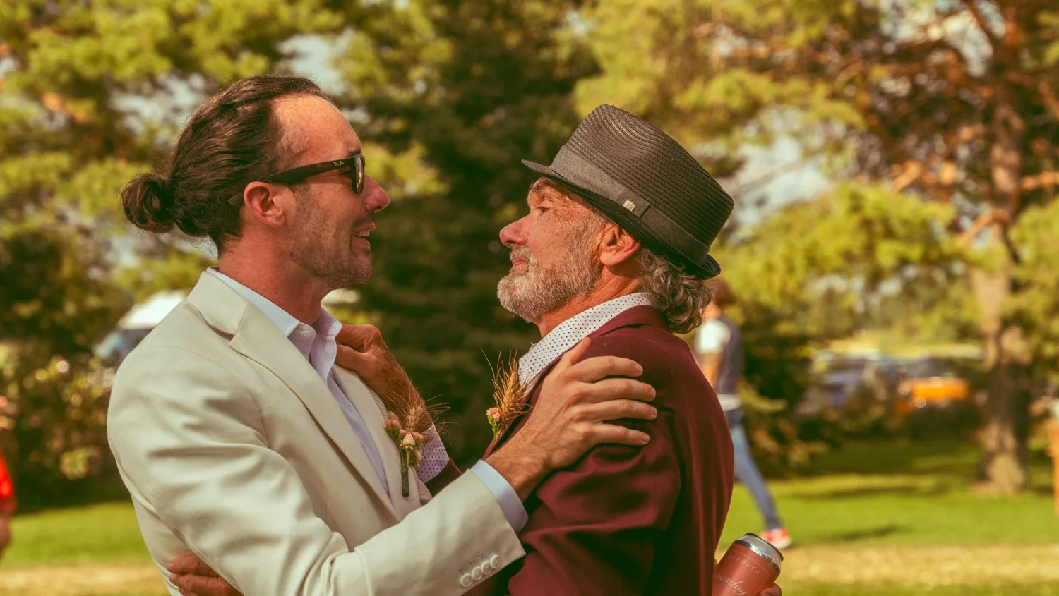 candid moment beautiful wedding hug father and son groom and father of the groom