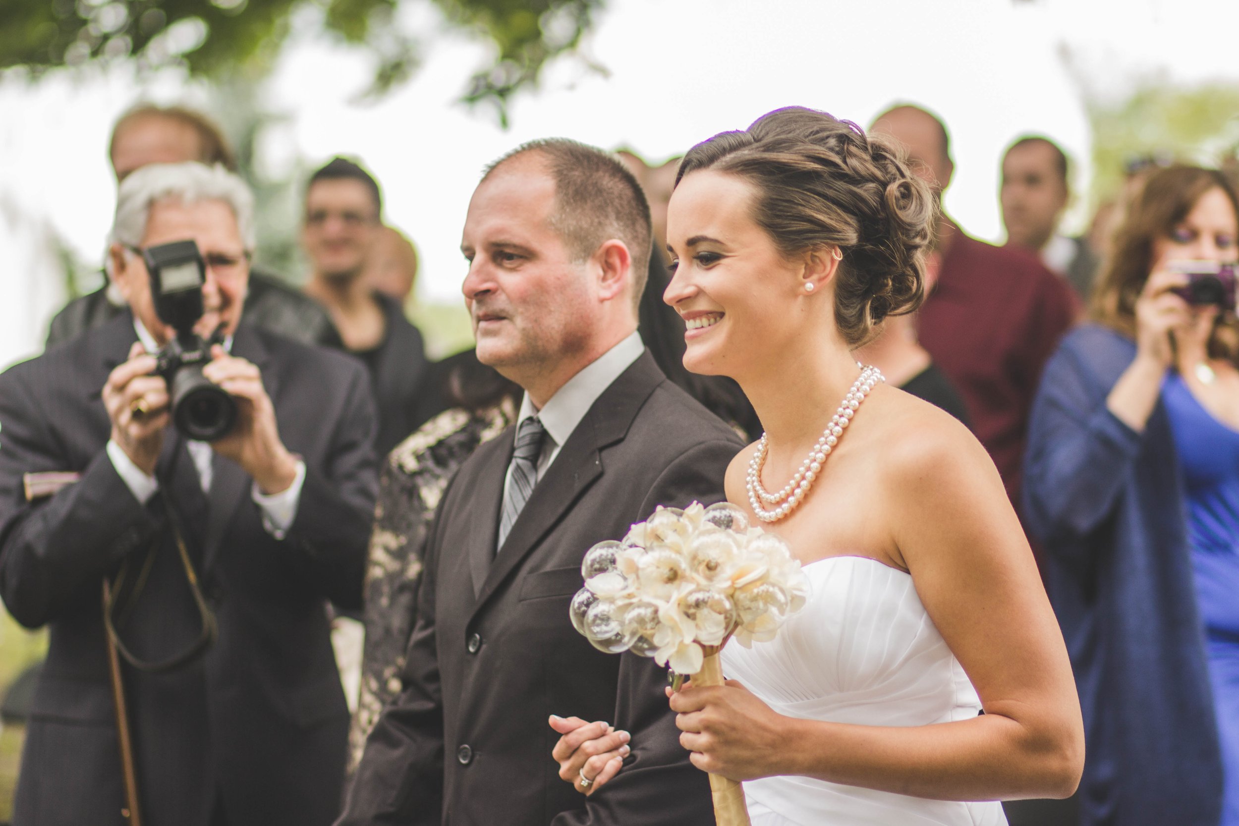 bride and father of the bride walking down the isle before their beautiful wedding