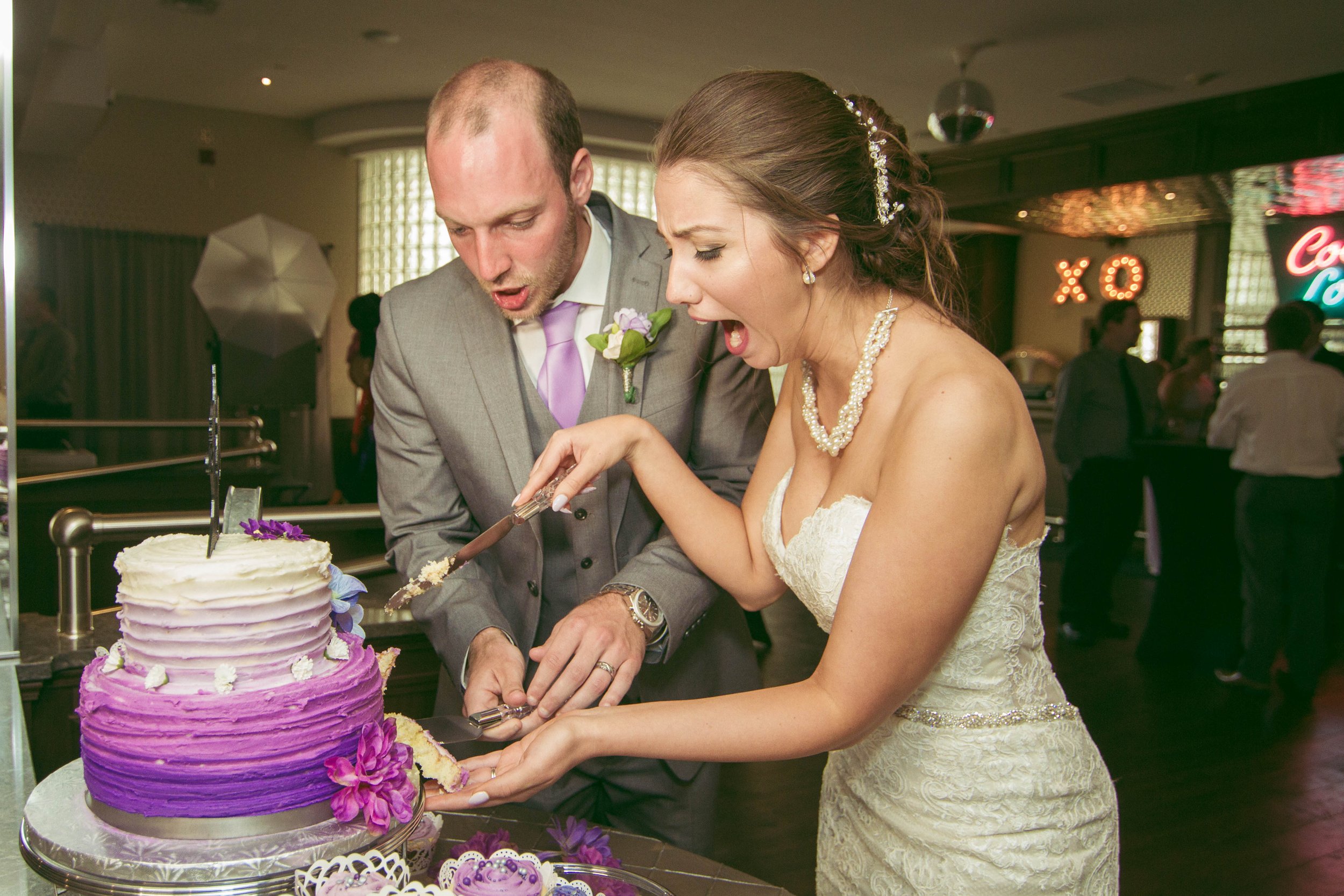 Bride and groom in love during their beautiful outdoor wedding cutting the cake