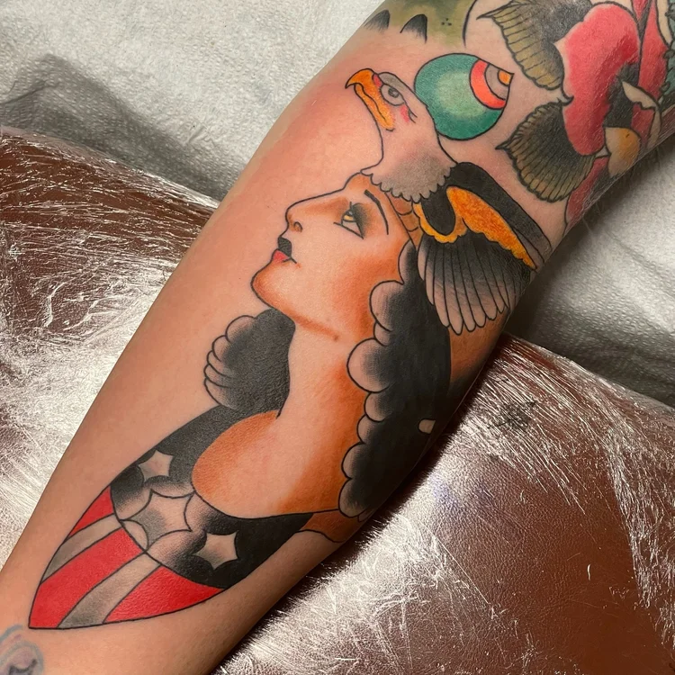 American Traditional woman's portrait tattoo with flowers and a bird