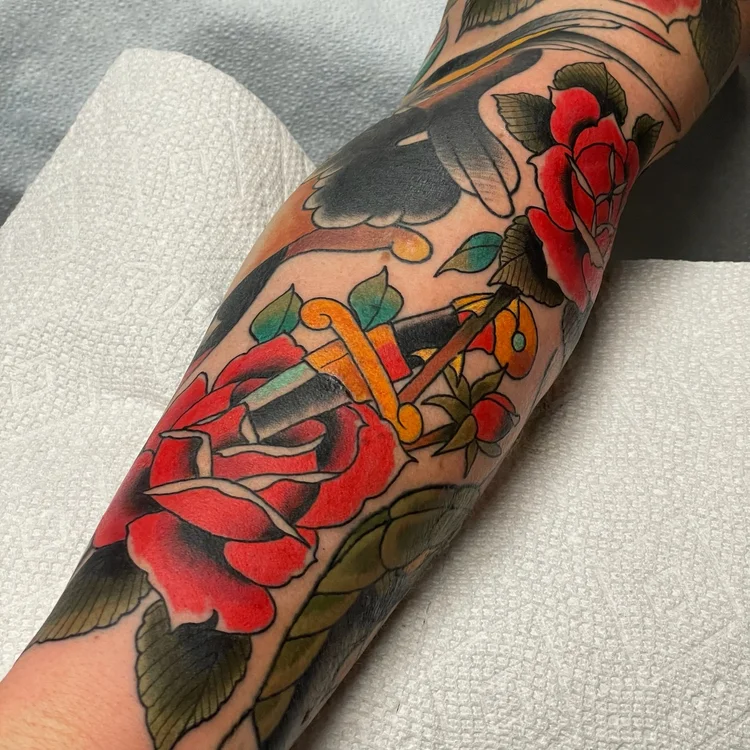 American Traditional dagger and red rose sleeve on the arm