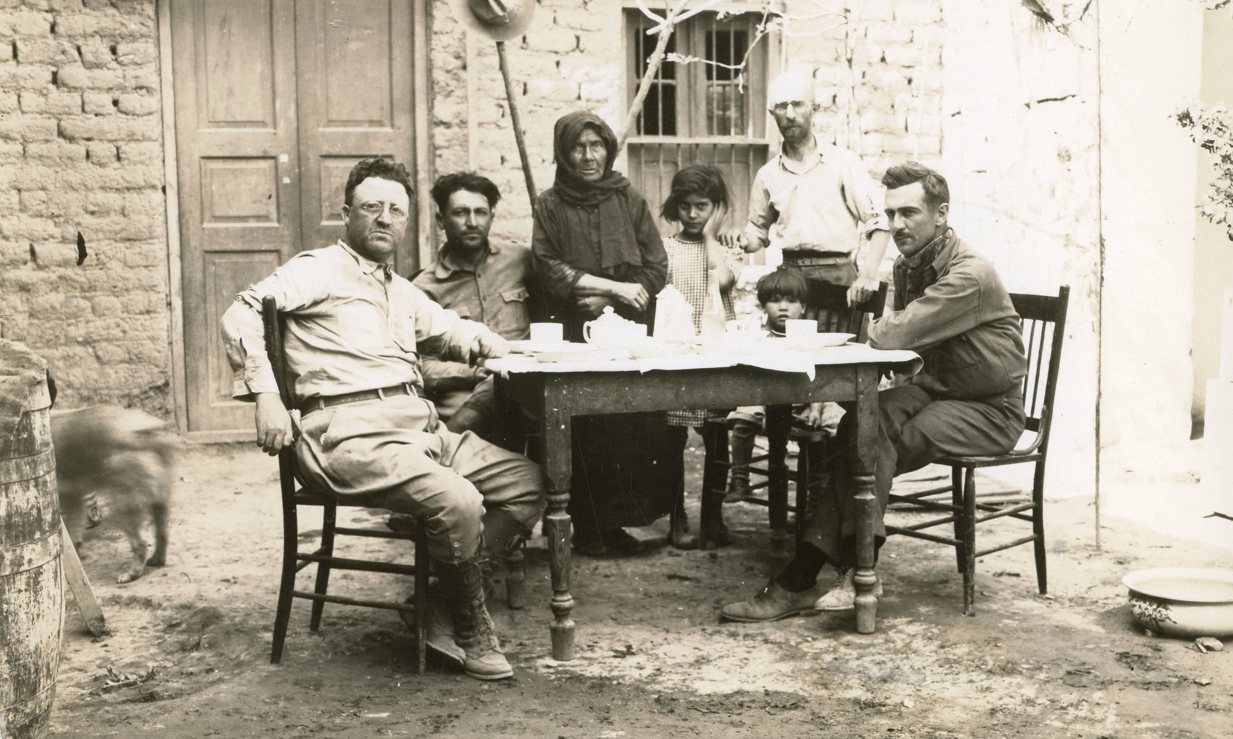 Three foreign correspondents, Abbe standing, with a local family while covering the war in Mexico 1929 © James Abbe Archive