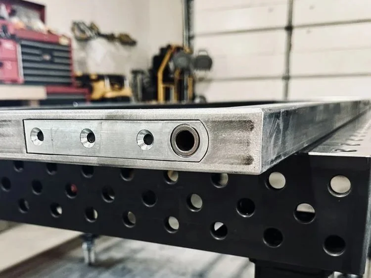 High-precision steel fabrication detail with pivot door hardware and machined holes