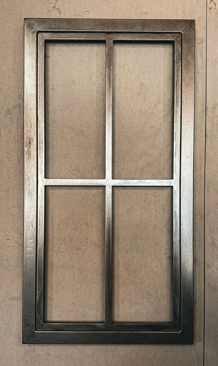 Custom metal cabinet door assembly detail with raw steel and clean machined edges in Denver metal shop