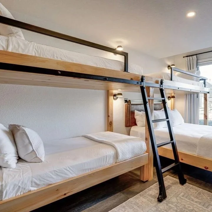 Metal-accent bunk beds with steel library ladder and hardware in modern ski chalet