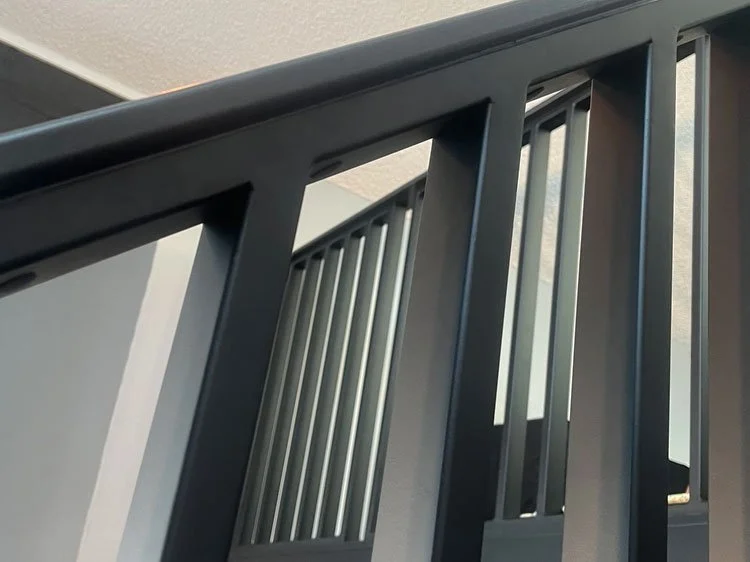Blackened steel stair railing with clean vertical balusters in mountain home