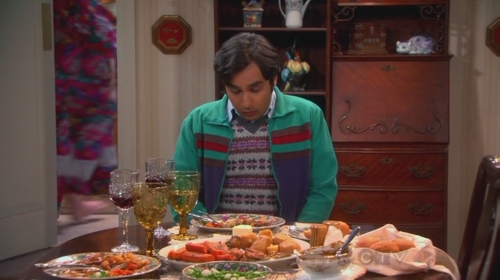 Screenshot from the TV show Big Bang Theory. A faceless Mrs. Wolowitz appears behind Raj as he eats dinner.