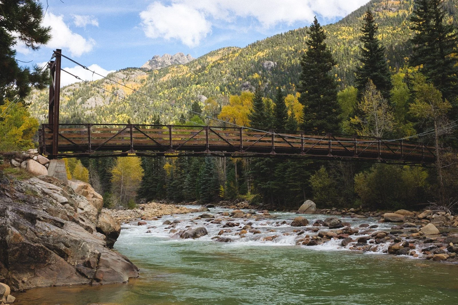 On our way out of the wilderness, crossing the pedestrian suspension bridge across the Upper Animas River to the narrow gauge rails. (October 2021)