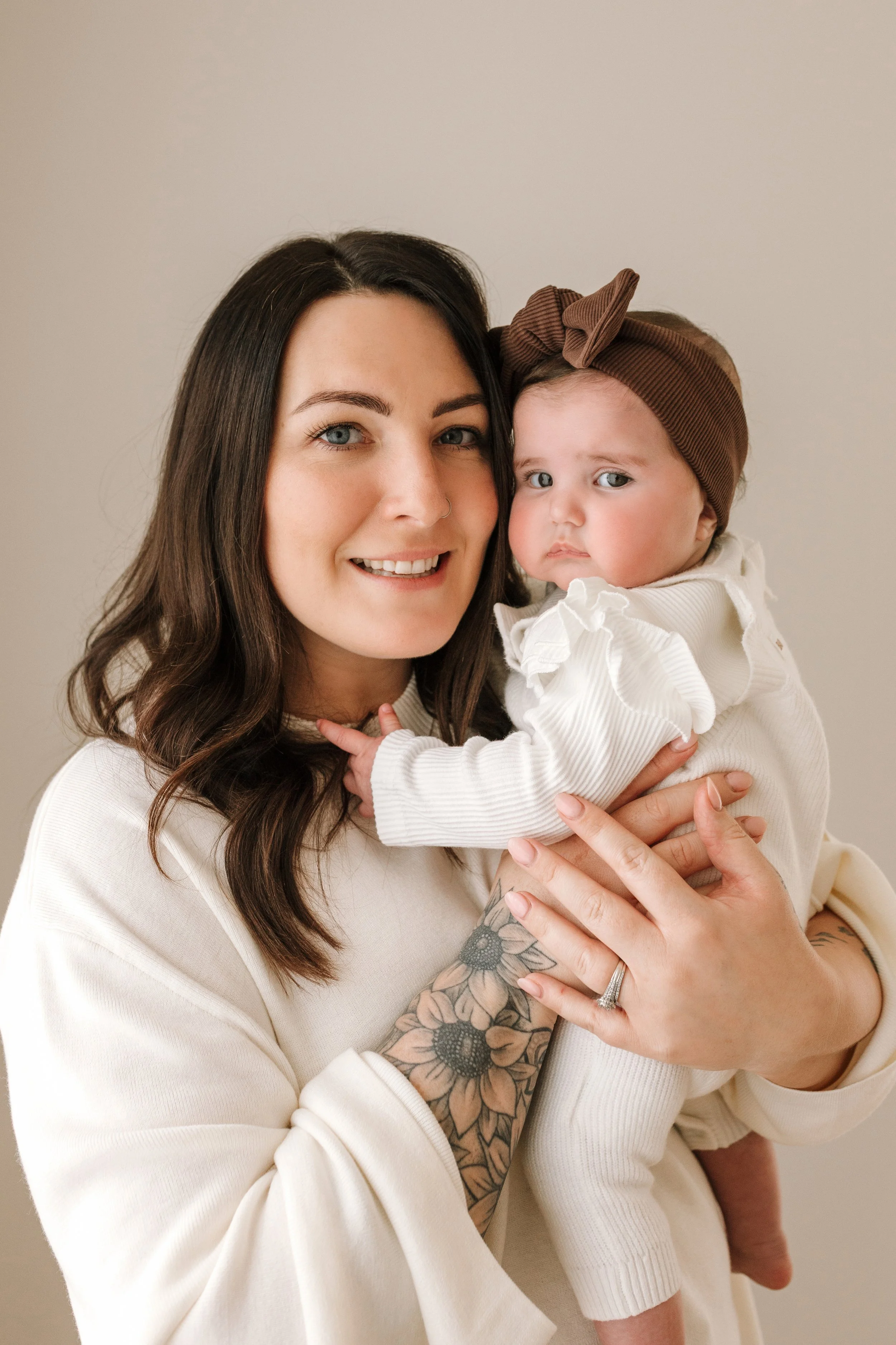 Mother embracing her children in a warm, neutral-toned family portrait studio.