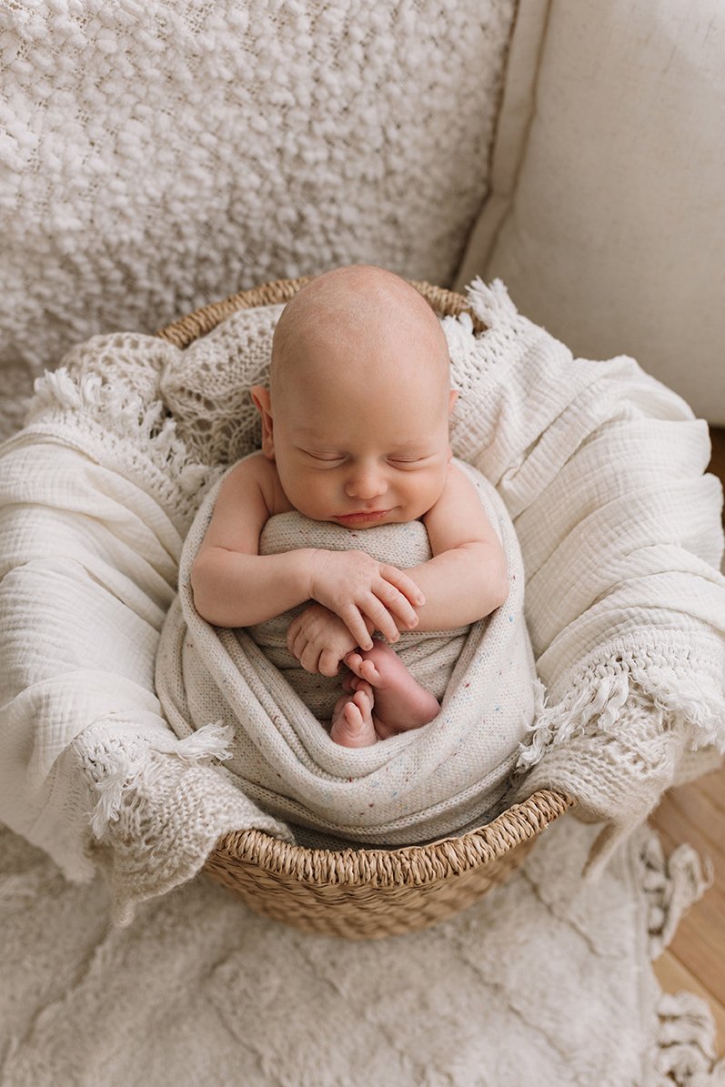 Newborn baby swaddled and sleeping peacefully.