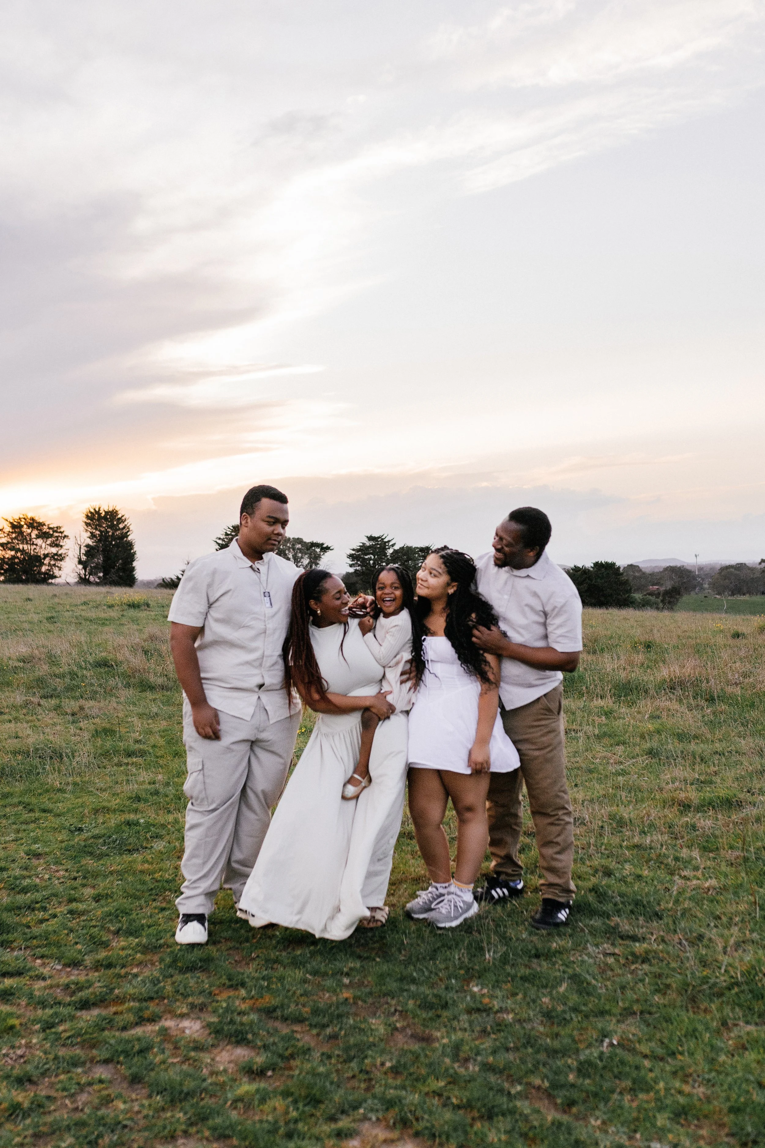 Family laughing together during a golden hour photography session.